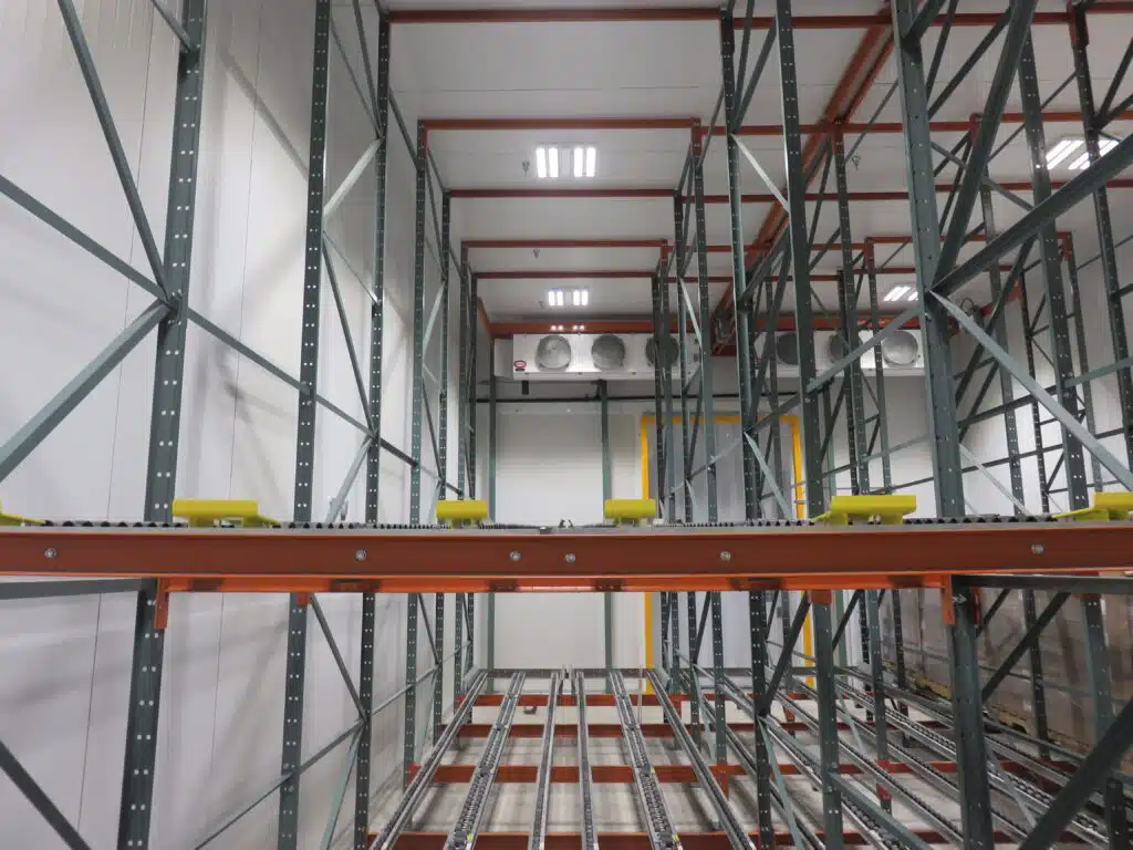Pallet flow pallet rack supporting a freezer structure